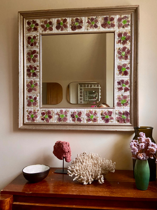 Large square ceramic mirror with floral decoration.