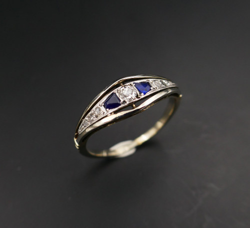 Anello giarrettiera con diamanti e zaffiri calibrati, oro e platino.