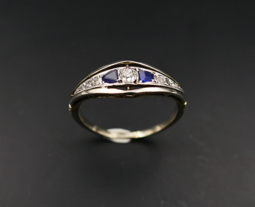 Anello giarrettiera con diamanti e zaffiri calibrati, oro e platino.