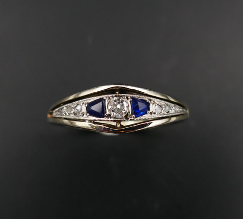 Anello giarrettiera con diamanti e zaffiri calibrati, oro e platino.