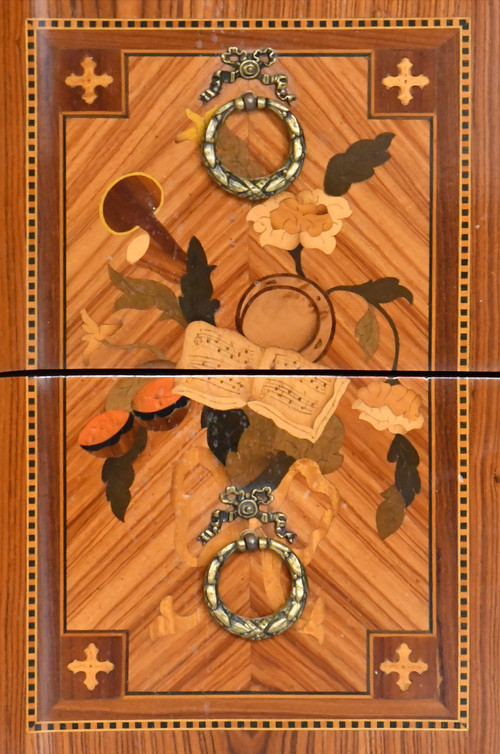 Commode de style Transition en marqueterie à décor de trophée aux instruments de musique 