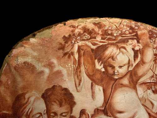 OIL ON OVAL WOOD PANELING DECORATED WITH CHERUBS CARRYING A FRUIT BOWL
