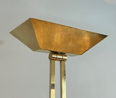 Lampada da terra in ottone con riflettore regolabile su base in travertino e ottone.