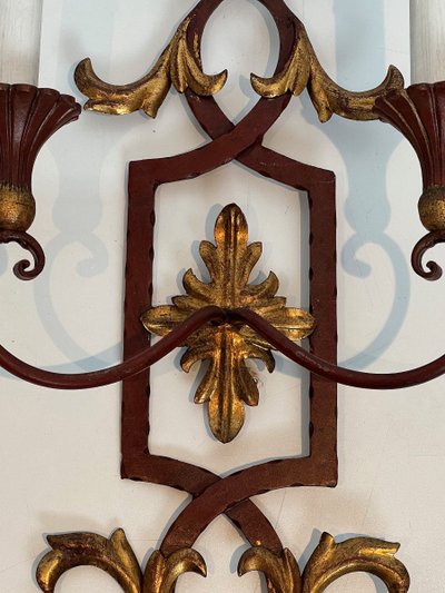 Coppia di applique in ferro battuto e legno rosso antico con foglie d'acanto dorate.