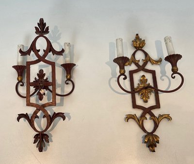 Coppia di applique in ferro battuto e legno rosso antico con foglie d'acanto dorate.