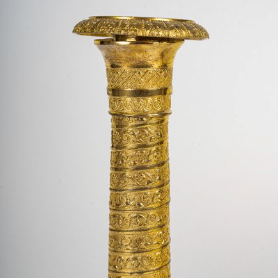 Ein Paar kleine Kerzenhalter aus vergoldeter Bronze mit Vendôme-Säulendekor aus der Empire-Epoche um 1810