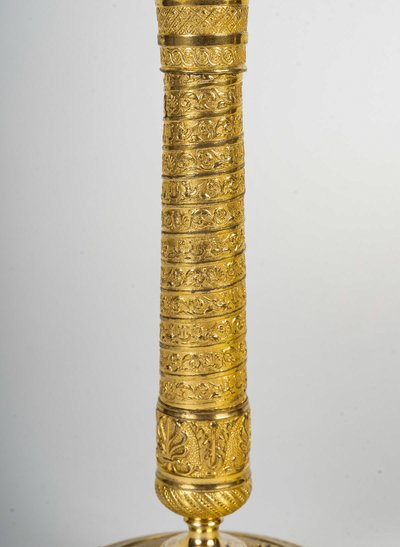 Ein Paar kleine Kerzenhalter aus vergoldeter Bronze mit Vendôme-Säulendekor aus der Empire-Epoche um 1810