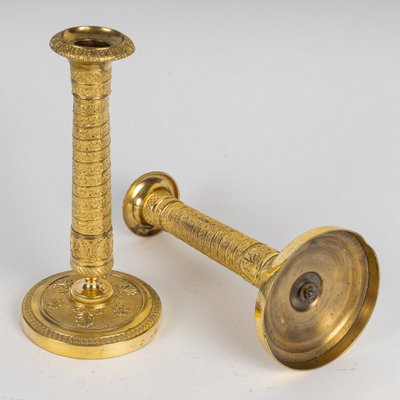 Ein Paar kleine Kerzenhalter aus vergoldeter Bronze mit Vendôme-Säulendekor aus der Empire-Epoche um 1810