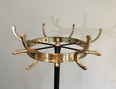 Appendiabiti in metallo laccato nero e ottone, opera francese di Jacques Adnet. Intorno al 1950