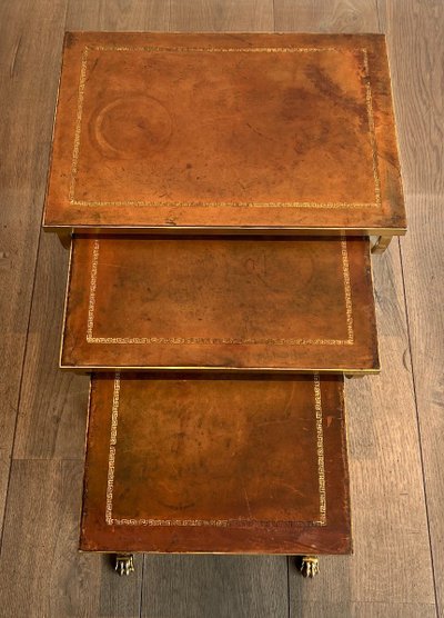 Suite di tavoli giganti in metallo dorato con piedini griffati e piastre in pelle. Opera francese