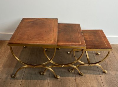 Suite di tavoli giganti in metallo dorato con piedini griffati e piastre in pelle. Opera francese