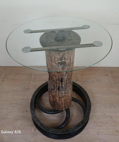 Design industriale per questo tavolo alto realizzato con una carrucola antica e un albero di legno