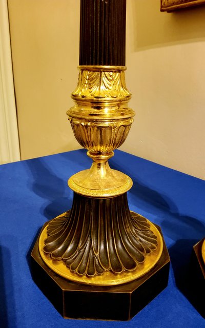 Coppia di antichi candelabri a colonna in bronzo con doppia patina, XIX secolo 