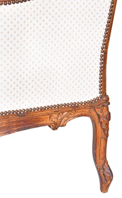 Fauteuil bergère à oreilles de style Louis XV en bois richement sculpté