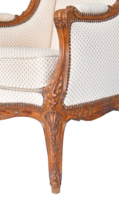 Fauteuil bergère à oreilles de style Louis XV en bois richement sculpté