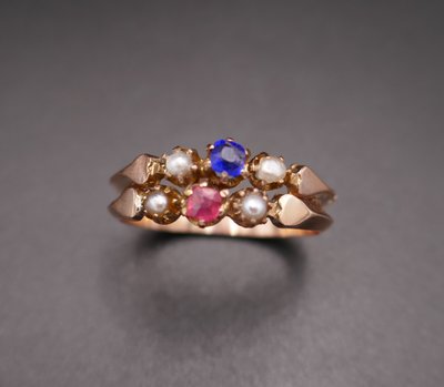 Antiker Ring mit Pferdekopf-Stempel, roten und blauen Steinen und Perlen.