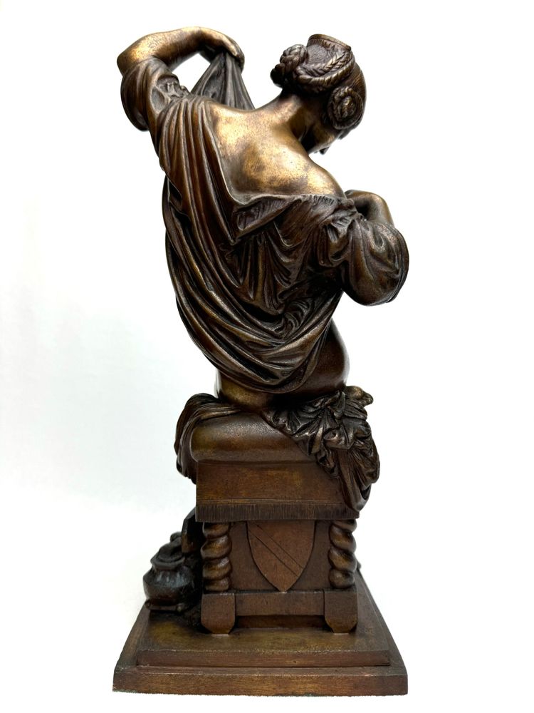 Scultura in bronzo raffigurante una donna seduta che si spoglia