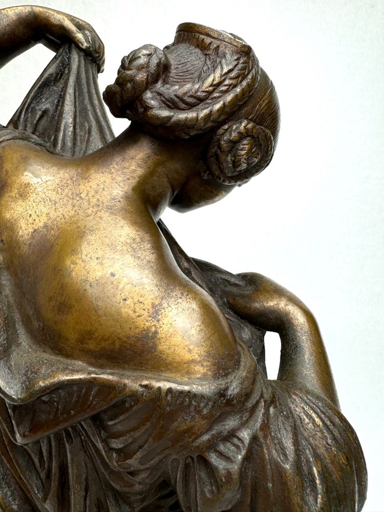 Scultura in bronzo raffigurante una donna seduta che si spoglia