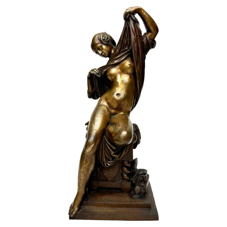 Scultura in bronzo raffigurante una donna seduta che si spoglia
