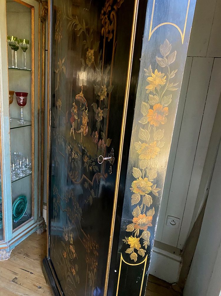 Angolo alto in legno laccato nero decorato con un vivace paesaggio e fiori
