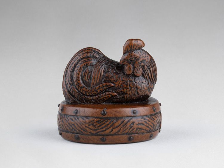 Netsuke di Tametaka. Modello in legno raffigurante un gallo appollaiato su un tamburo. Edo Giappone