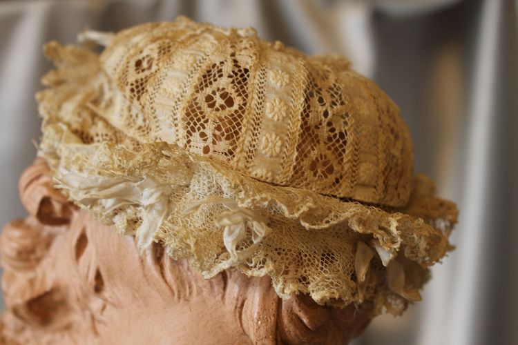 Cuffietta in pizzo batista color avorio per neonato o bambola, inizio XX secolo 