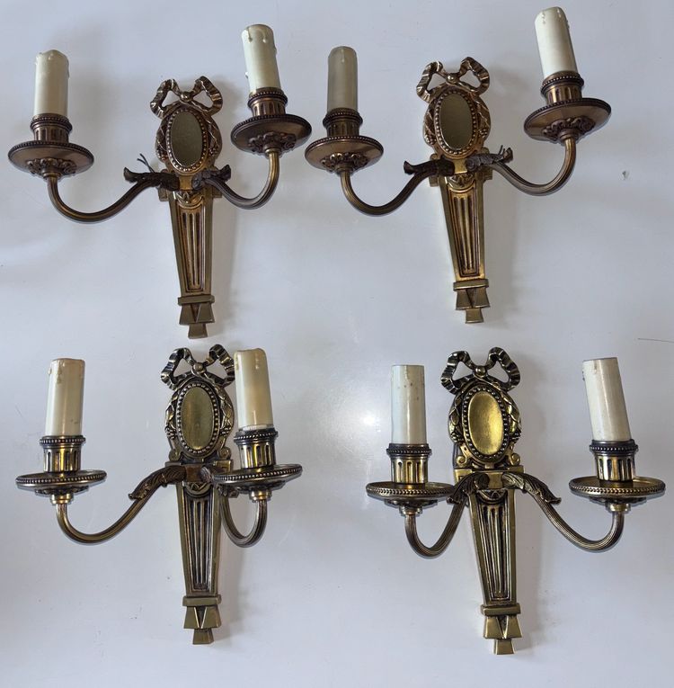 PETITOT (20th century) Series of four Art Deco wall lights with medallions, in chiseled gilt bronze