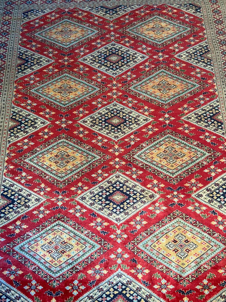 Grande tappeto pakistano firmato in lana lavorato a mano con disegno geometrico su fondo rosso