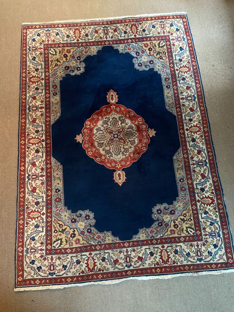 NAIN hand-knotted wool oriental rug with central medallion on midnight blue background