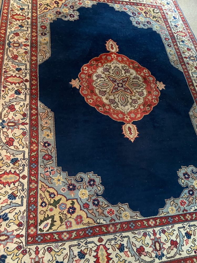 NAIN hand-knotted wool oriental rug with central medallion on midnight blue background