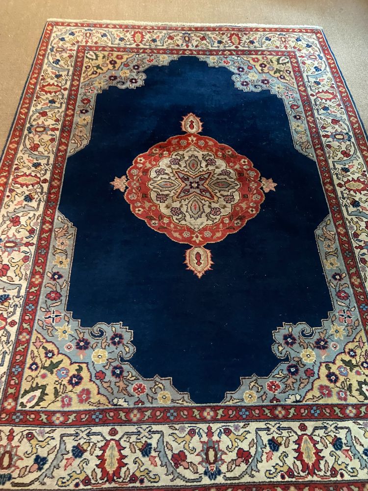 NAIN hand-knotted wool oriental rug with central medallion on midnight blue background
