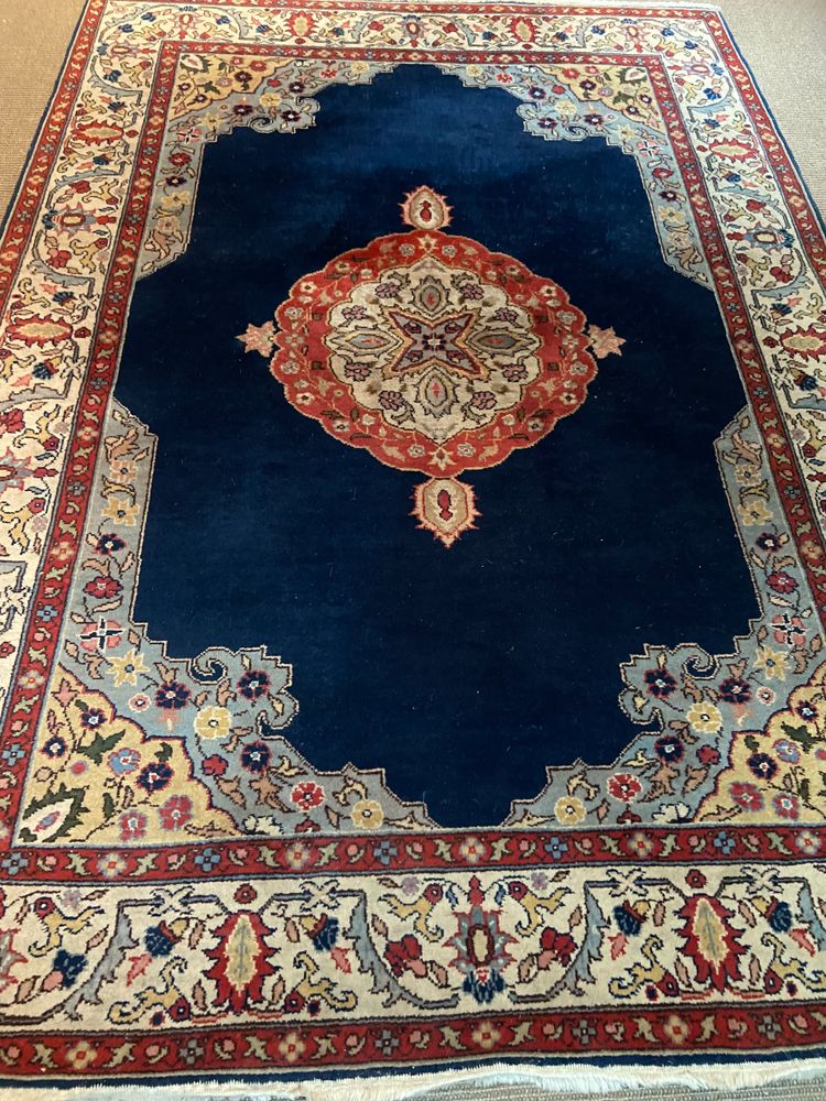 NAIN hand-knotted wool oriental rug with central medallion on midnight blue background