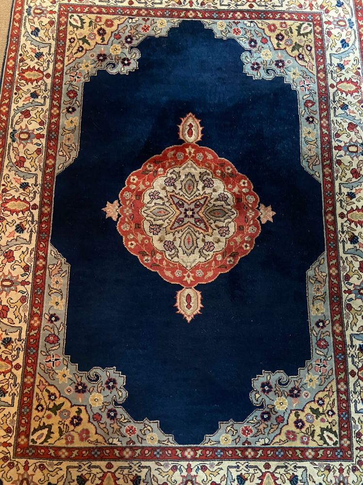 NAIN hand-knotted wool oriental rug with central medallion on midnight blue background