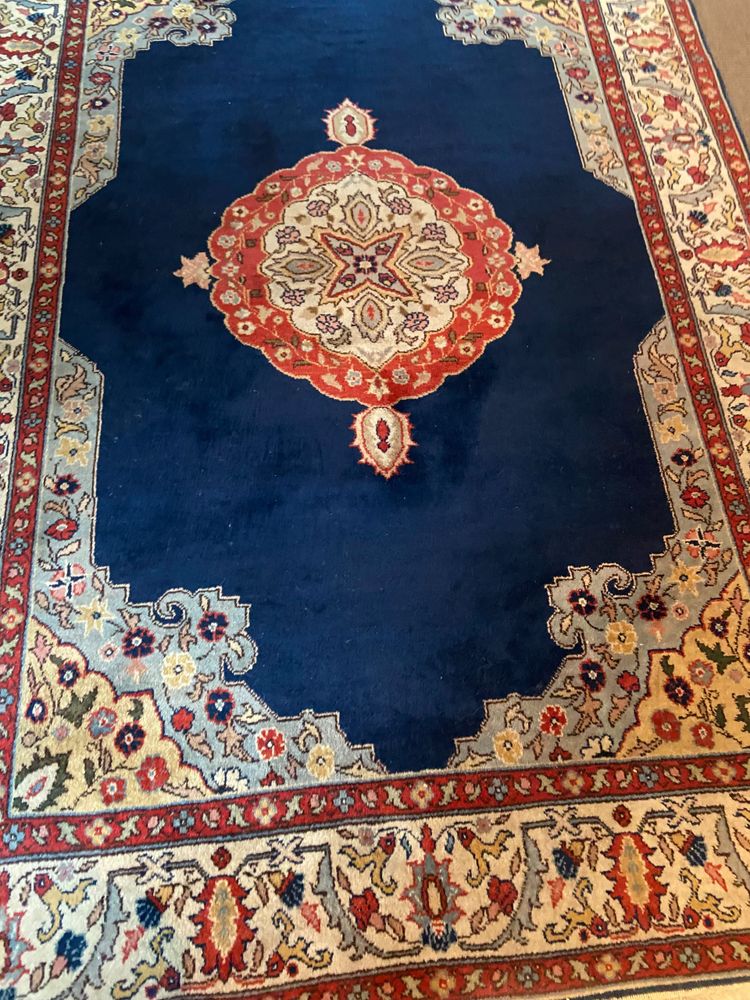 NAIN hand-knotted wool oriental rug with central medallion on midnight blue background