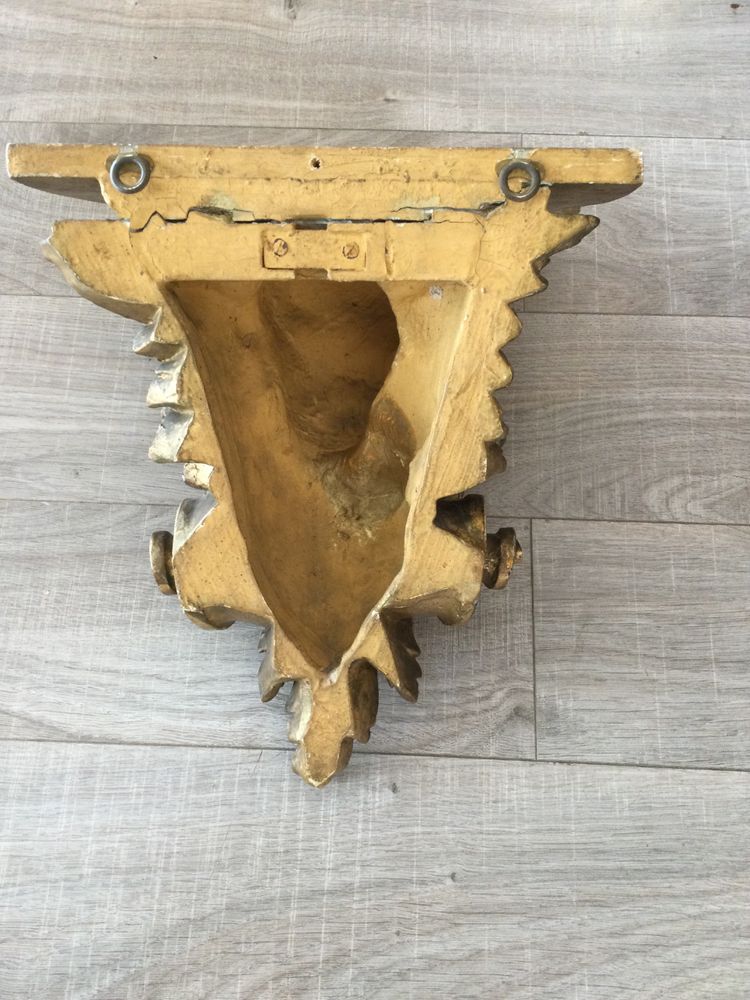 Une console murale en bois doré à tête d'angelot.