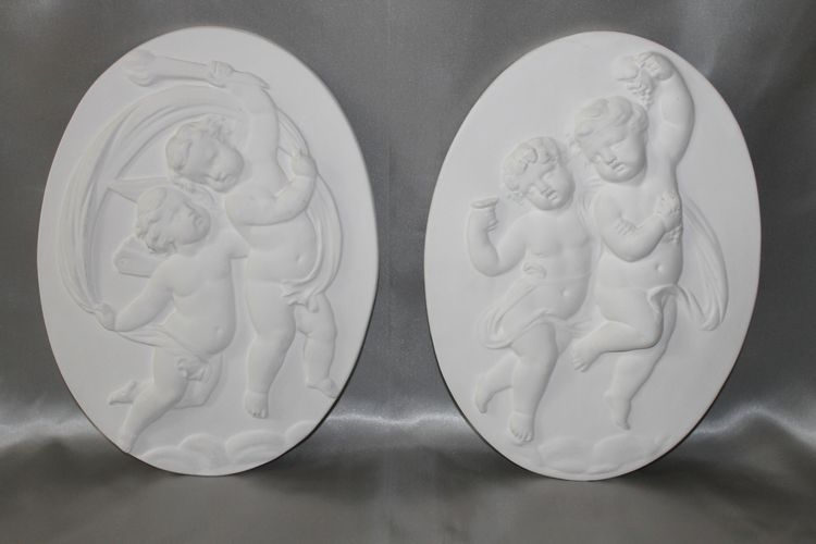 Pair of plaster bas-reliefs decorated with cherubs in the Louis XVI style, 20th century.