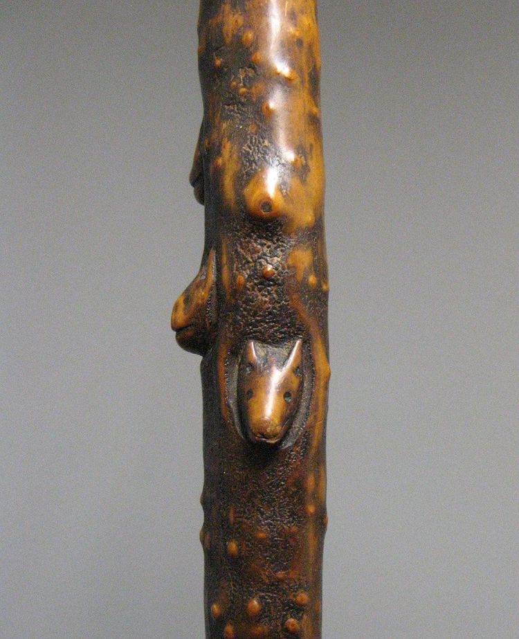Canna d'arte popolare monossile intagliata con animali e teste grottesche XIX sec.