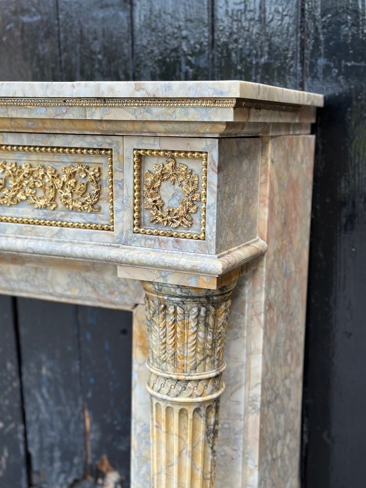 Camino in stile Luigi XVI in marmo giallo Siena e bronzi dorati