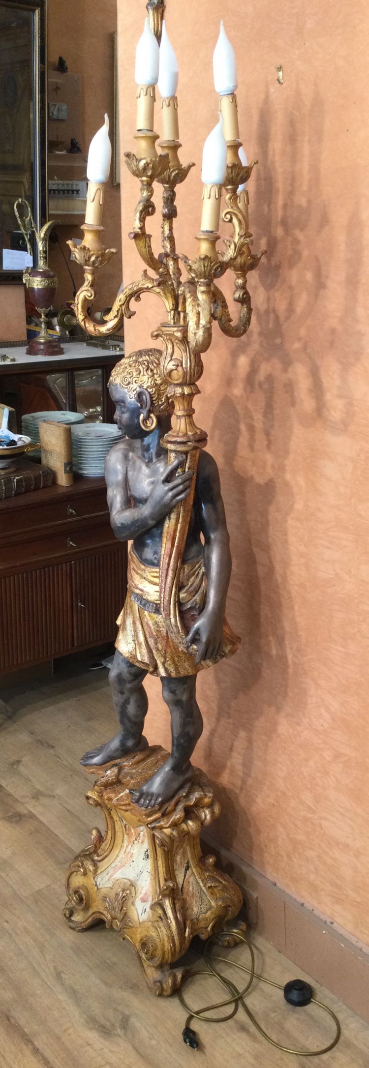 A large "Nubian" floor lamp in the Italian Baroque style, in painted and gilded wood.