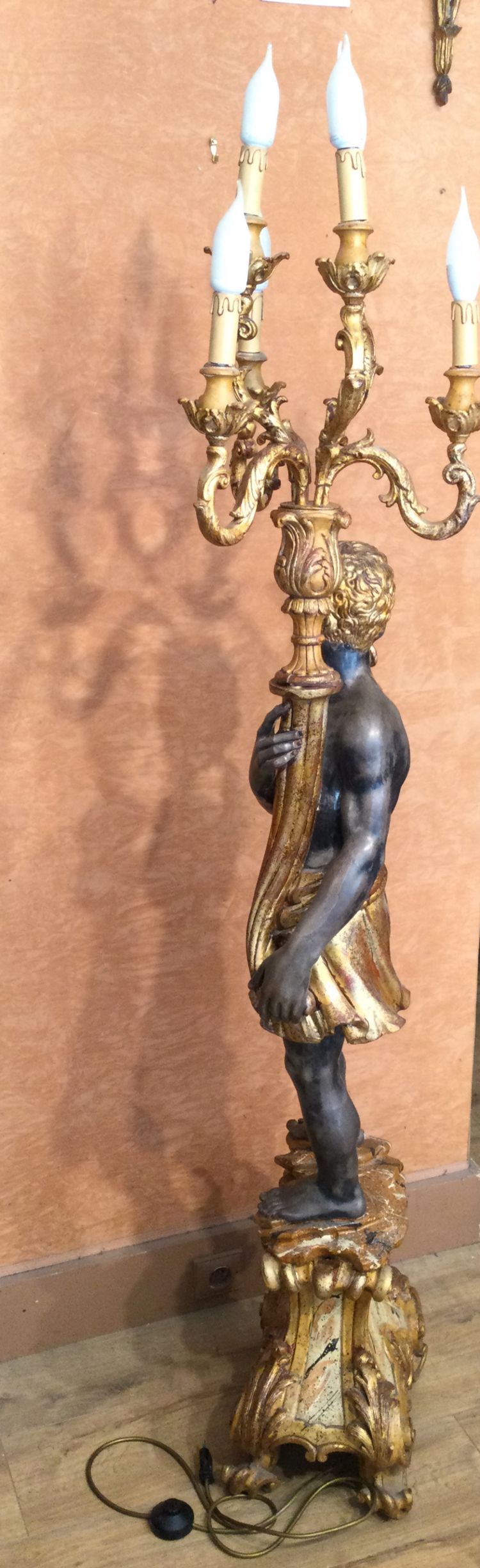 A large "Nubian" floor lamp in the Italian Baroque style, in painted and gilded wood.