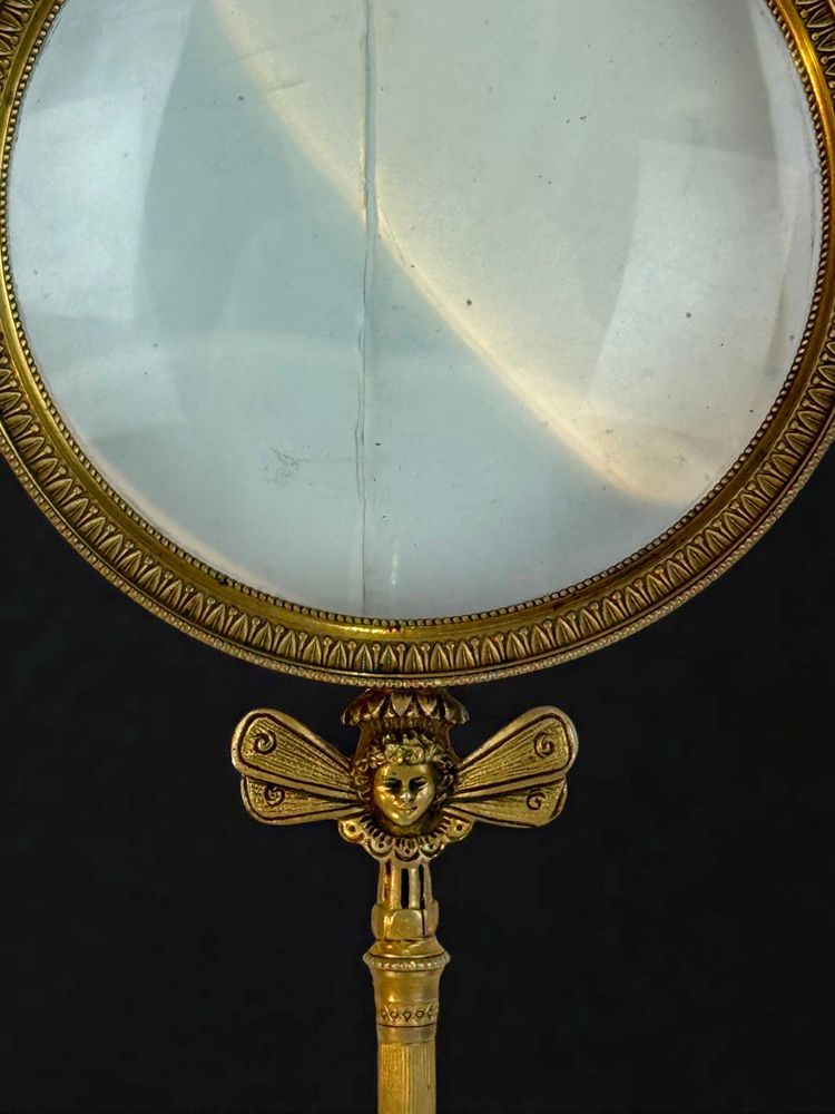 LARGE EMPIRE PERIOD MAGNIFYING GLASS IN CHASED AND GILDED BRONZE WITH WINGED FEMALE HEAD DECORATION