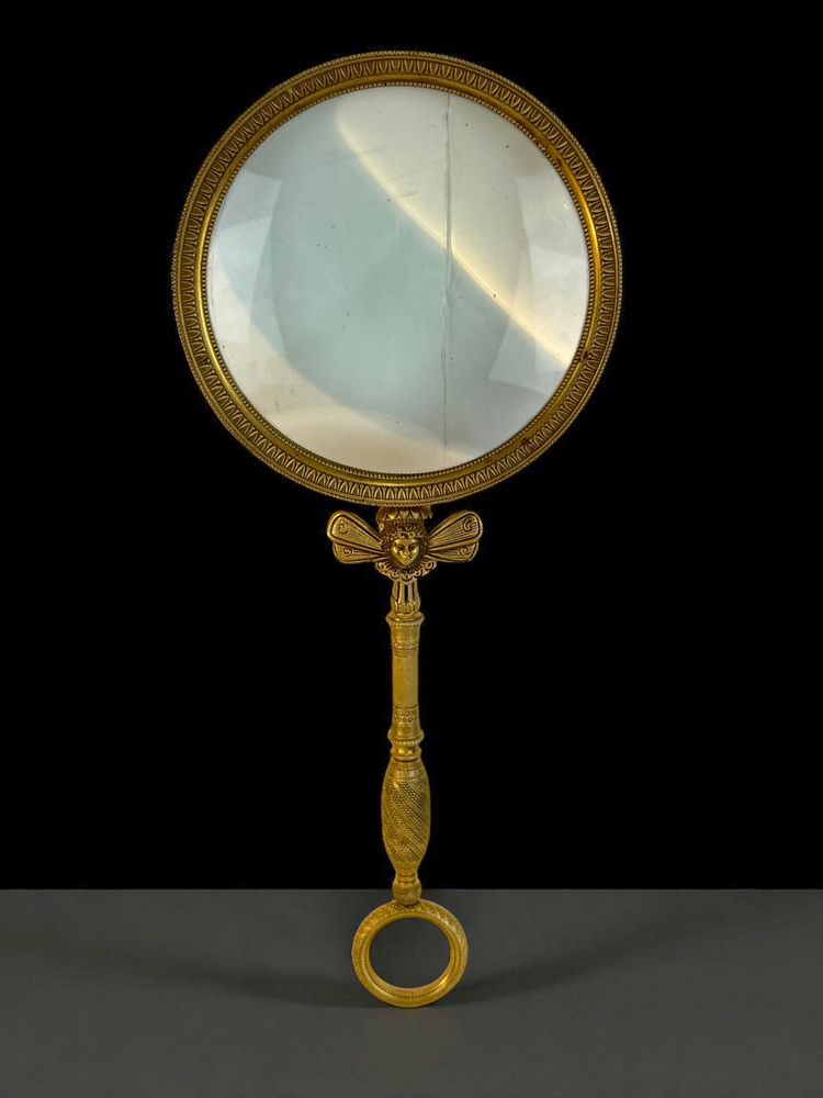 LARGE EMPIRE PERIOD MAGNIFYING GLASS IN CHASED AND GILDED BRONZE WITH WINGED FEMALE HEAD DECORATION
