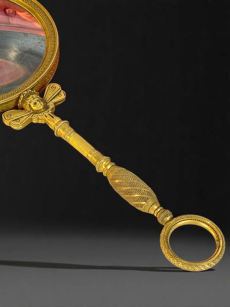 LARGE EMPIRE PERIOD MAGNIFYING GLASS IN CHASED AND GILDED BRONZE WITH WINGED FEMALE HEAD DECORATION