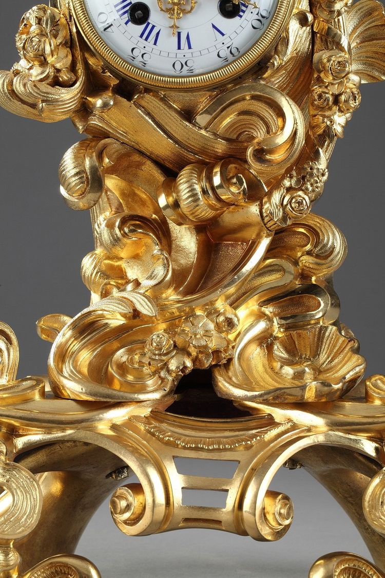 Pendule de style Rocaille en bronze doré, ornée d'un Amour dans une coquille
