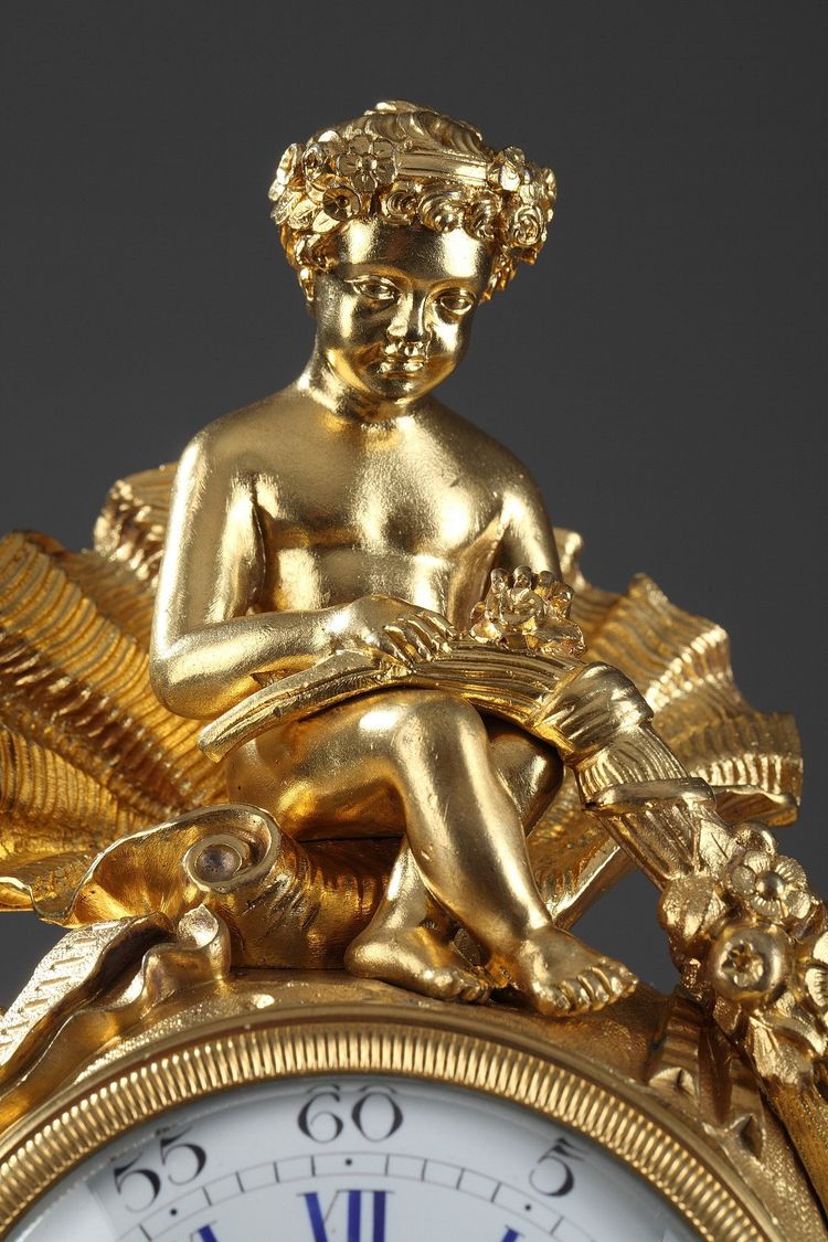 Pendule de style Rocaille en bronze doré, ornée d'un Amour dans une coquille