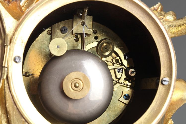 Pendule de style Rocaille en bronze doré, ornée d'un Amour dans une coquille