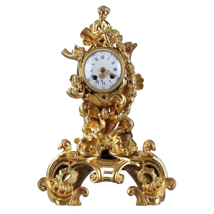 Pendule de style Rocaille en bronze doré, ornée d'un Amour dans une coquille