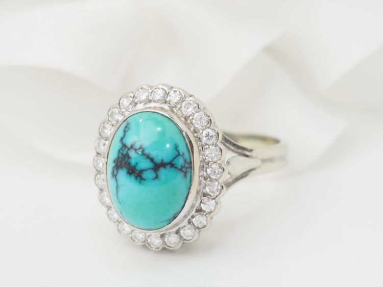 Anello con contorno in oro bianco, diamanti e turchese cabochon