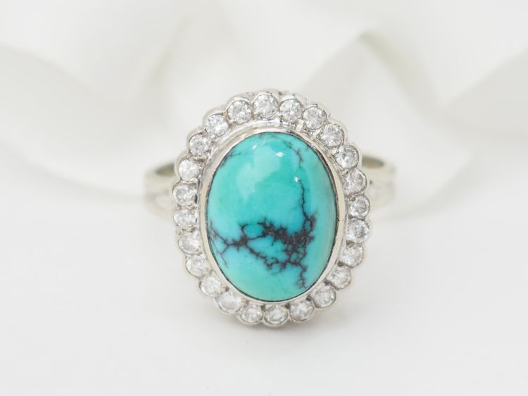 Anello con contorno in oro bianco, diamanti e turchese cabochon