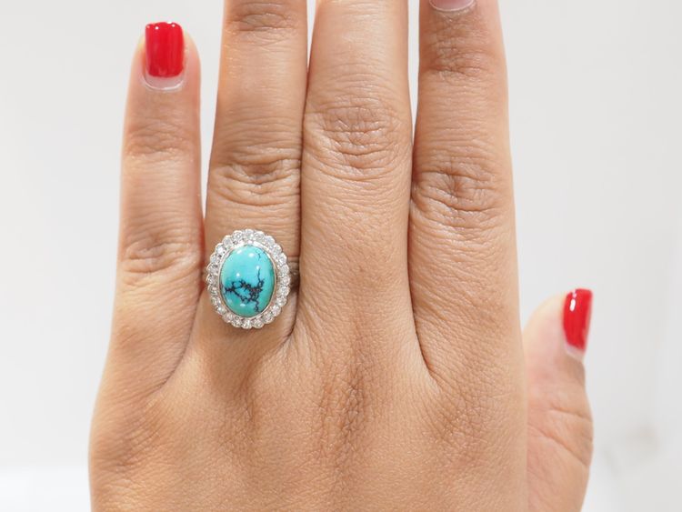 Anello con contorno in oro bianco, diamanti e turchese cabochon